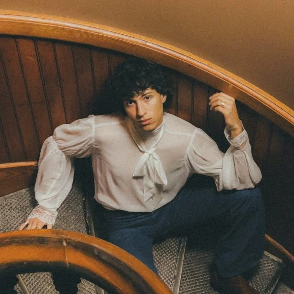 teenage boy sitting on vintage spiral staircase