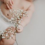 baby touching delicate flowers