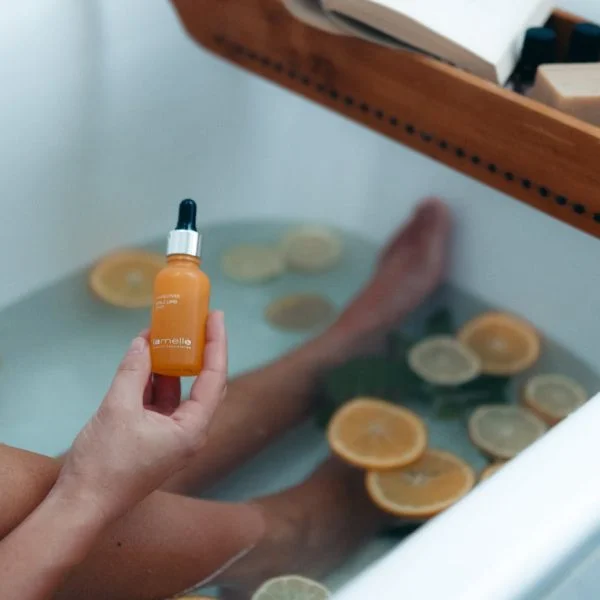person holding orange and black plastic bottle